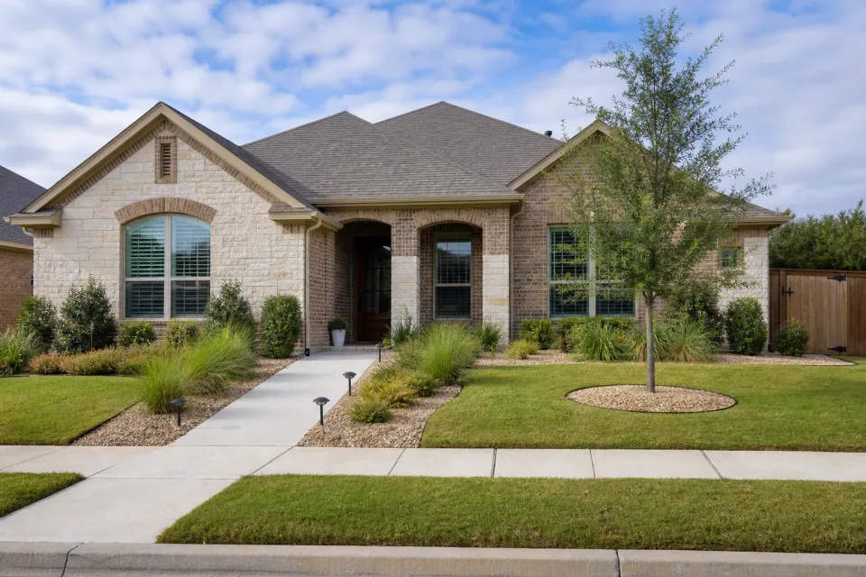 Neighborhood front yard with clean lawn edges and desert planting